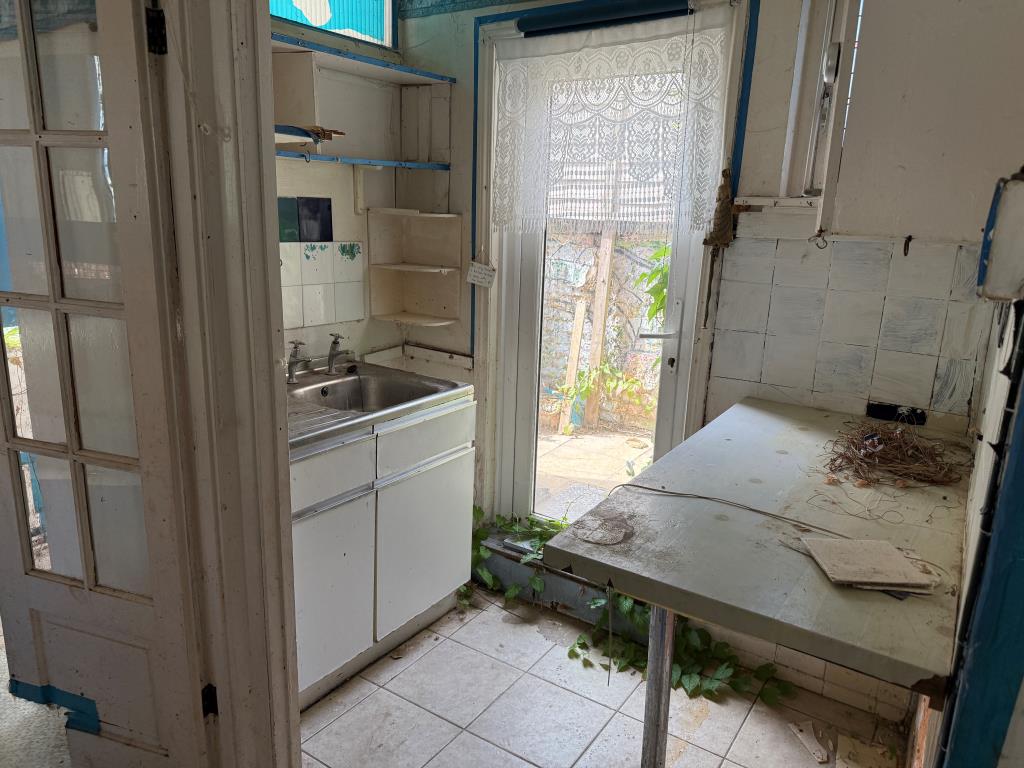 Lot: 146 - PATIO FLAT IN NEED OF REFURBISHMENT - Kitchen with units and glazed side door to patio